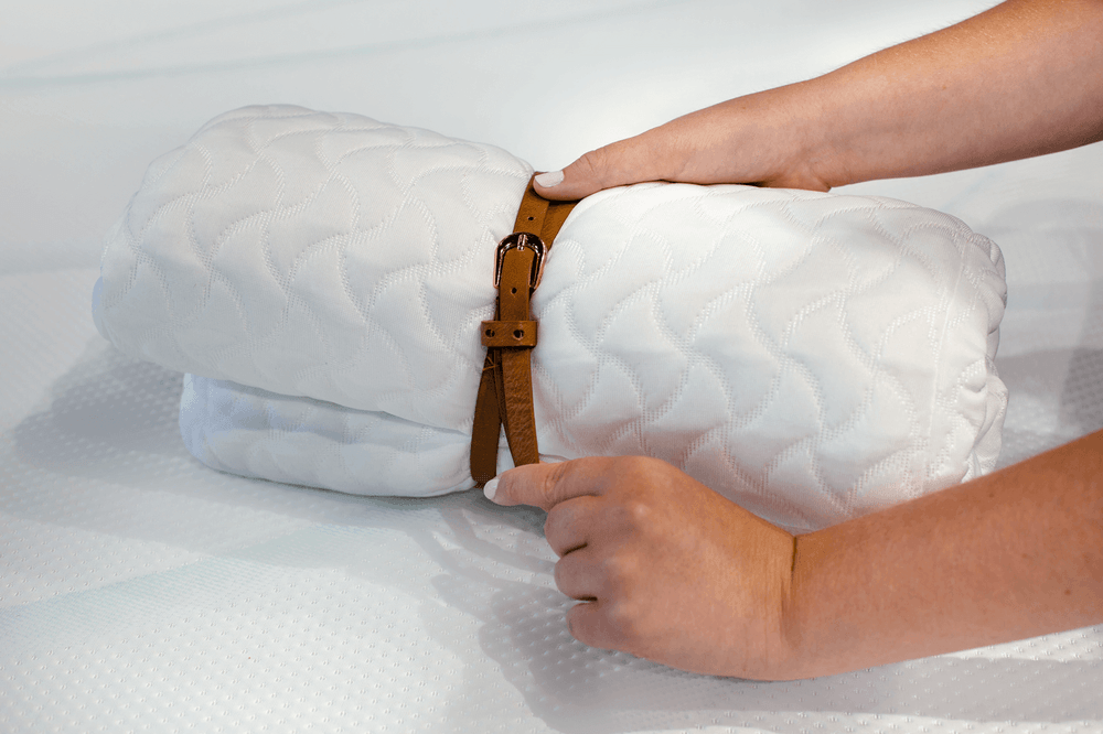 a rolled tempur cloud pillow being secured with a belt